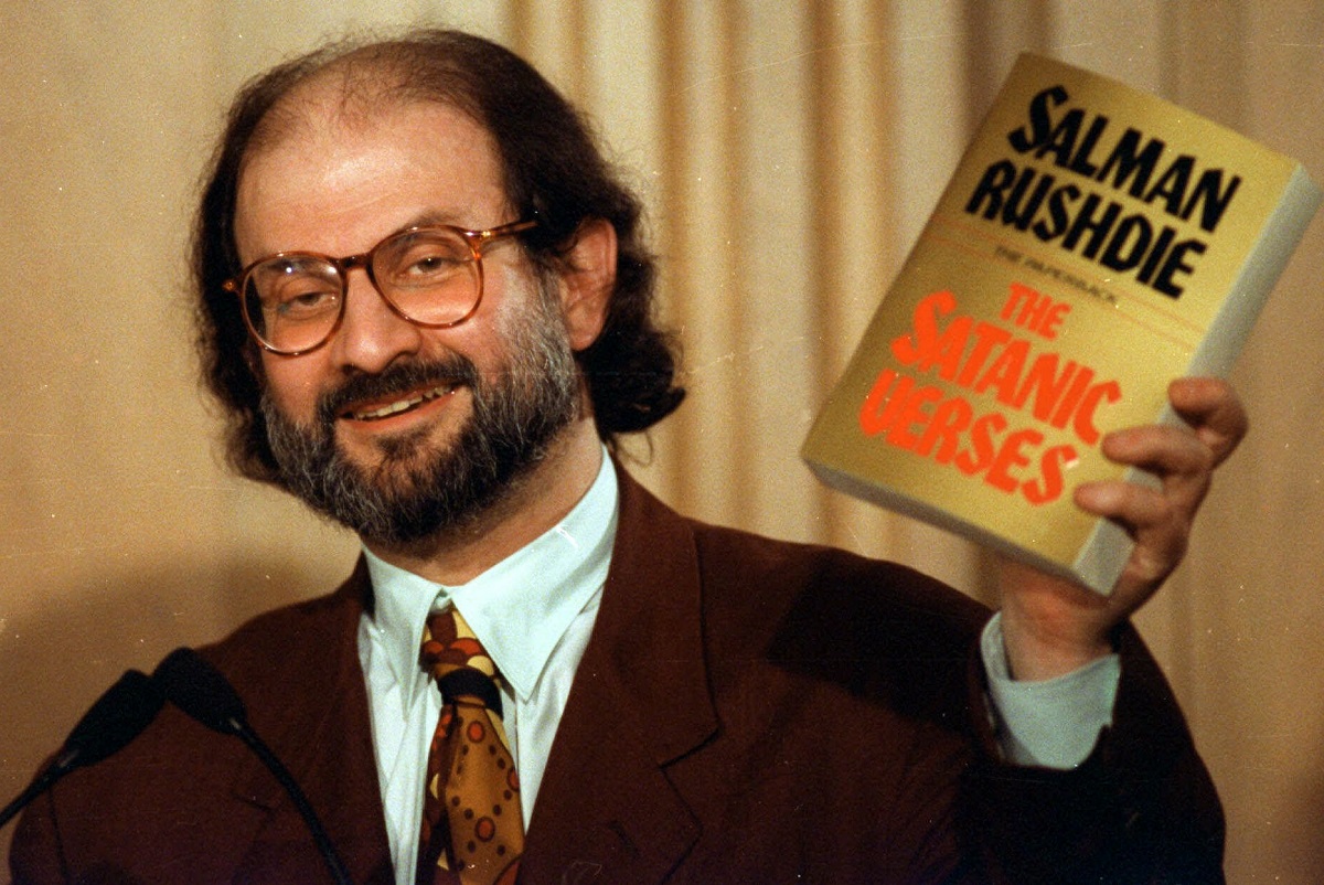 author salman rushdie holds up a copy of his controversial book the satanic verses.jpg